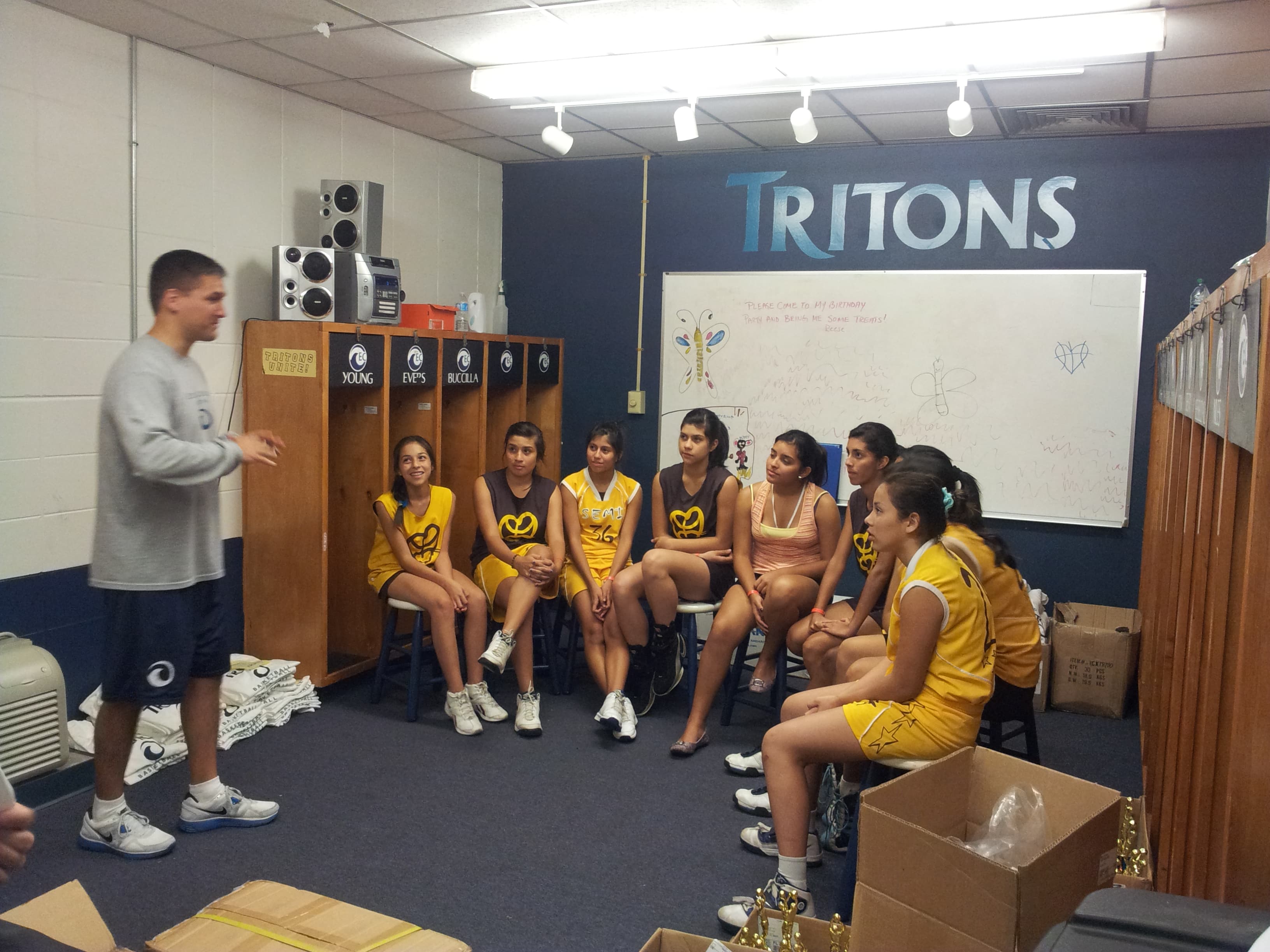 Equipo femenino de baloncesto reunido con su entrenador